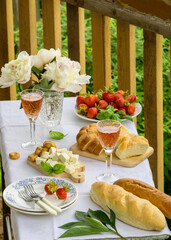 Wall Mural - Summer picnic table with various snacks and rose wine outdoors