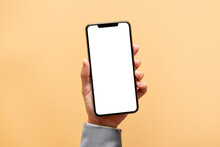 Smartphone Mockup. Close Up Hand Holding Black Phone White Screen On Yellow Background. Mobile Phone Frameless Design Concept.