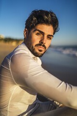 Poster - Vertical picture of a brunette male with a white shirt under the sunlight