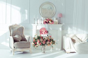 luxury clean bright white interior. a spacious room with sunlight and flowers in vases and royal chic furniture. 