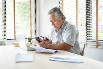 Wall Mural - Stressed Asian Elderly male calculate family budget and Debt