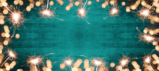 Wall Mural - Frame of lights bokeh lights flares and sparkler isolated on Abstract turquoise painted wooden texture - Holiday New Year's Eve Silvester celebration background banner 