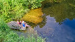 © Iuliia Sokolovska - Happy family and friends fishing together outdoors near lake in summer, aerial top view from above