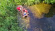 © Iuliia Sokolovska - Happy family and friends fishing together outdoors near lake in summer, aerial top view from above