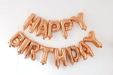 Happy Birthday! Rose gold sparkling balloons on white background. Celebration party anniversary decoration composition