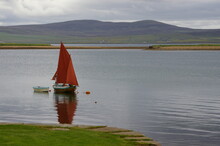 A Small Yacht With Red Sails Moored At Stromness, Orkney Islands, Scotland, UK.