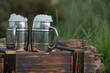 Wooden charred box. Two mugs with beer, white beer foam. Flame tanned wood. Blurred garden background.