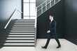 © Who is Danny - Businessman walking in minimalistic concrete hall