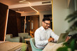 © bnenin - Elegant smiling man using laptop in the luxury hotel room, portrait.
