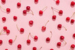 Leinwandbild Motiv Flat lay of cherries on a pink background.