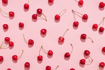 flat lay of cherries on a pink background.
