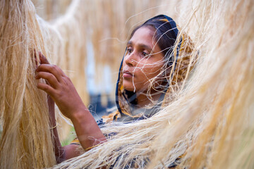a female worker is processing the fibers from the pineapple leaves and letting them dry in the sun. 