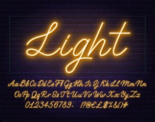 Wall Mural - Neon yellow script font. Glowing alphabet with letters, numbers and special characters on a brick background.