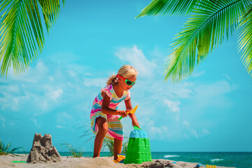 Poster - cute little girl play with sand on tropical beach