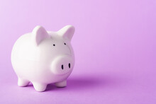 Front Small White Fat Piggy Bank, Studio Shot Isolated On Purple Background And Copy Space For Use, Finance, Deposit Saving Money Concept