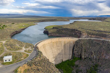 Fron Large View Of An Arch Gravity Dam Across Lava Canyon Cutting Into A Plateau, Creating A Reservoir Behind, A Road Crossing The Top, Salmon Falls Dam, Idaho