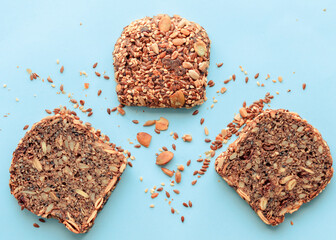 Sliced whole grain bread rye with seeds flax, sunflower, pumpkin and sesame.Healthy food, eco-friendly natural products. Fresh bread on a pink background.