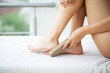 Woman cleans the heel of the foot with pumice