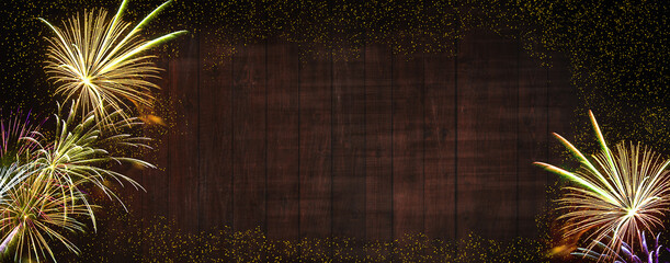 Wall Mural - fireworks, golden sylvester-fireworks with golden particles on black-brown wooden background and spa