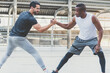 © Patcharanan - Two handsome muscular athletes  men are doing a handshake pose to stretch before exercising.