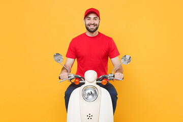 Wall Mural - Delivery man in red cap t-shirt uniform driving moped motorbike scooter isolated on yellow background studio Guy employee working courier Service quarantine pandemic coronavirus virus covid-19 concept