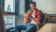 © GalakticDreamer - Tranquil adult man using smartphone against elegant interior in contemporary apartment