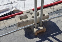 Detail Of Anchoring Building Fence. Double Protection Of The Steel Fence Post. Steel Fence Roll-over Protection. Edge Of The Construction Of An Industrial Complex. Fencing Of Construction Works.