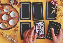 Wiccan Witch Reading The Future At Her Altar Using 5 Card Tarot Spread On Bright Yellow Cloth (flat Lay) Hand Painted Death Tarot Card With Tarot Deck In Woman's Hand With Candles And Dried Flowers