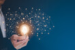 © Bussarin - Businessman hold the light bulb in graph Screen Icon of media screen,Technology Process System Business concept.