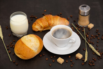 Breakfast in the morning with black coffee cup with bread with Croissant and fruit on the black background.