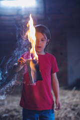 Preteen child, burning paper in the attic