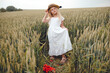 © Олег Кошевський - little girl with a straw hat. beautiful little girl with blond hair in a white dress in the background of a beautiful field. Girl with a bouquet of red poppies