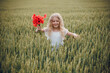 © Олег Кошевський - beautiful little girl with blond hair in a white dress in the background of a beautiful field. Girl with a bouquet of red poppies