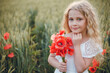 © Олег Кошевський - beautiful little girl with blond hair in a white dress in the background of a beautiful field. Girl with a bouquet of red poppies
