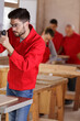 © auremar - younger carpenter works in workshop