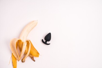 Anal plug and a peeled banana isolated on a white background