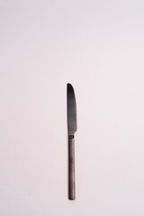 Wall Mural - Vertical shot of a knife isolated on a light-colored background