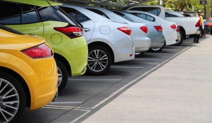 closeup of rear, back side of orange color car with other cars parking in indoor parking area in bri