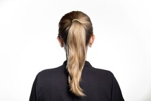 Back view of young female dirty blonde hair straight hair ponytail black shirt white background