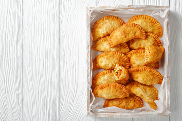 Sticker - deep fried empanadas on a wooden tray