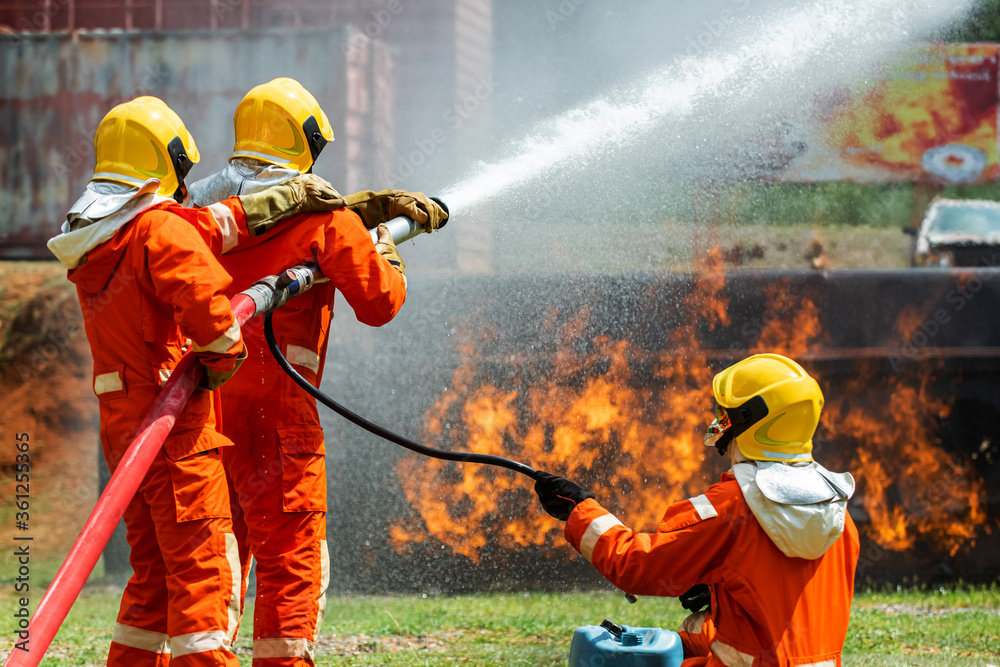 Group of firefighter in fire suit using water and chemical foam from ...