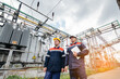 © Andrii - Two specialist electrical substation engineers inspect modern high-voltage equipment in the evening. Energy. Industry