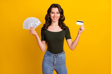 Poster - Portrait of her she nice attractive lovely cheerful cheery wavy-haired girl holding in hands bank card cash wealth isolated on bright vivid shine vibrant yellow color background