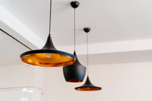 Copper Chandelier Painted Black On Ceiling. Lighting In Interior.