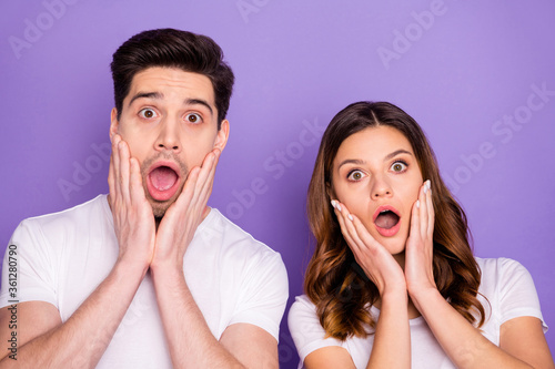 Closeup photo pretty lady handsome guy shocked couple open mouth arms cheeks listen news corona virus quarantine covid 19 wear casual white t-shirts isolated purple pastel color background