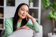 © deagreez - Close up photo of nice content charming asian girl look enjoy holiday sit divan in house indoors