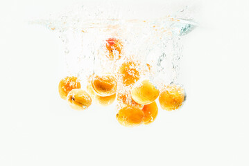 Wall Mural - Apricots are falling in the clear water with splash.