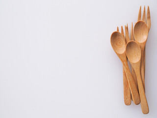 wooden spoon and fork on white cutting board background