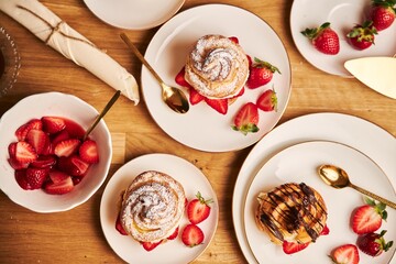 Poster - Overhead shot of delicious cream puff with strawberries and chocolate on a wooden table