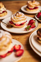 Poster - Vertical closeup shot of delicious cream puff with strawberries  on a wooden table